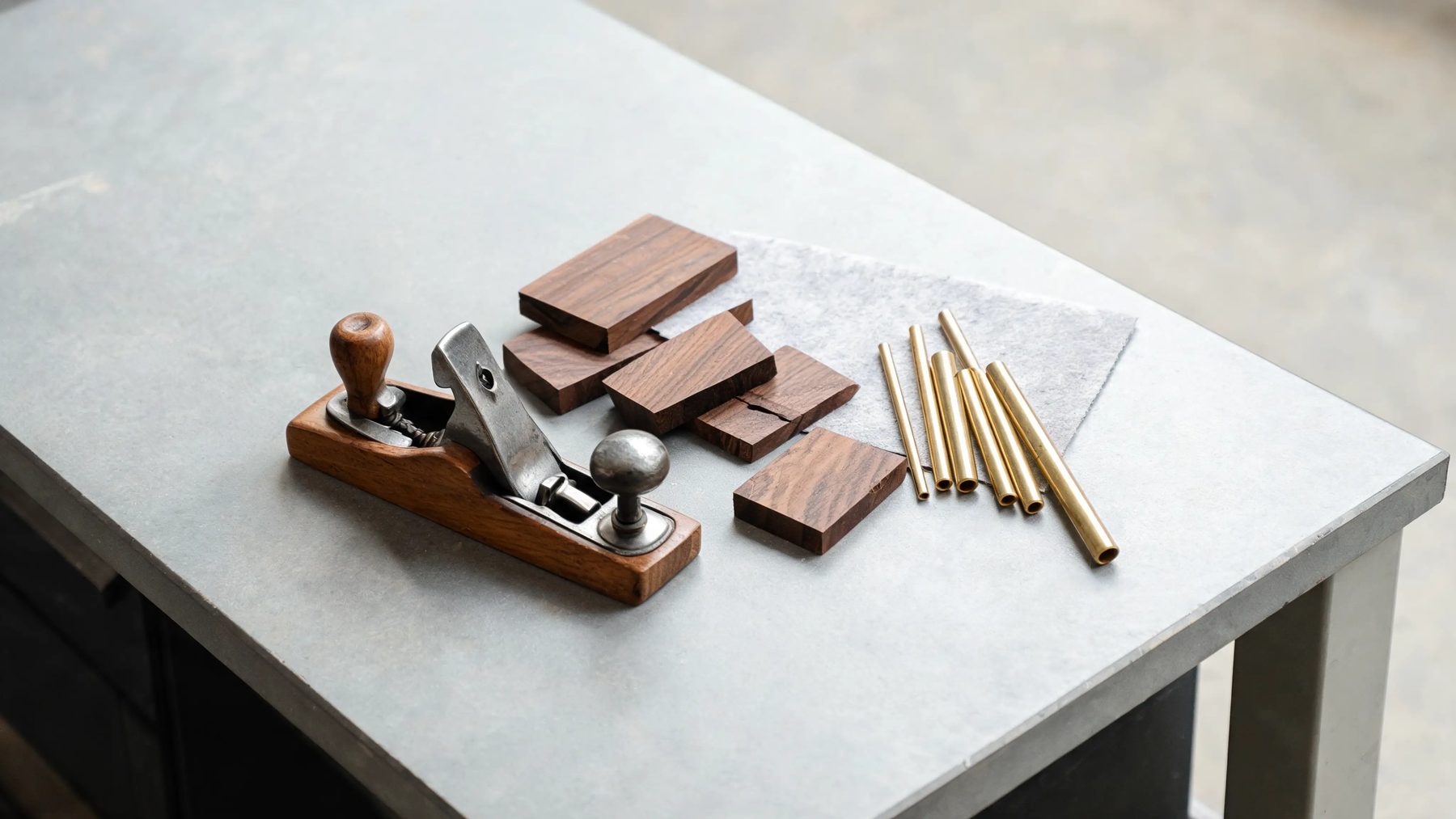 Workshop bench with a hand plane, walnut offcuts and brass rod stock